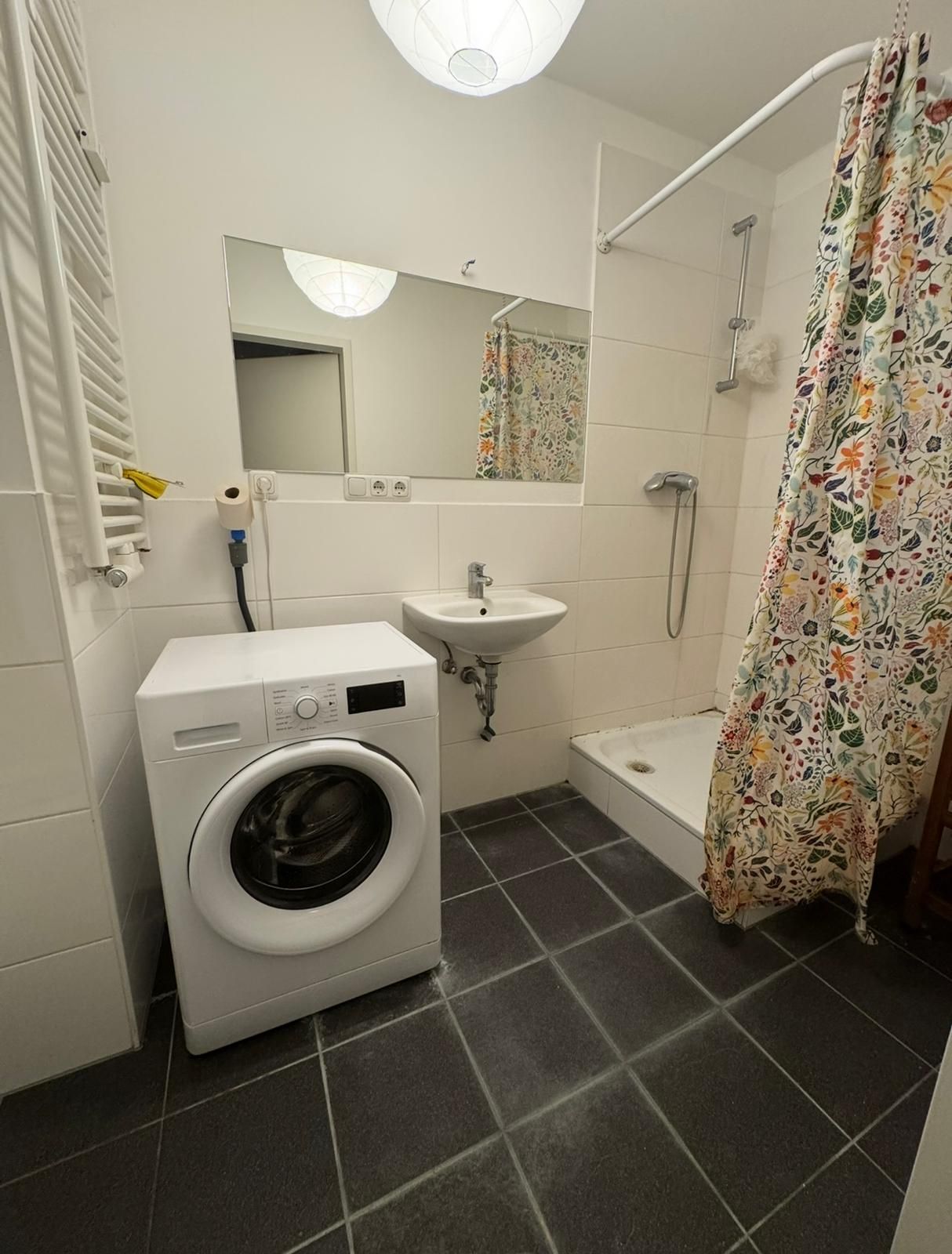 Bad mit Dusche, Waschbecken, Spiegel und Waschmaschine