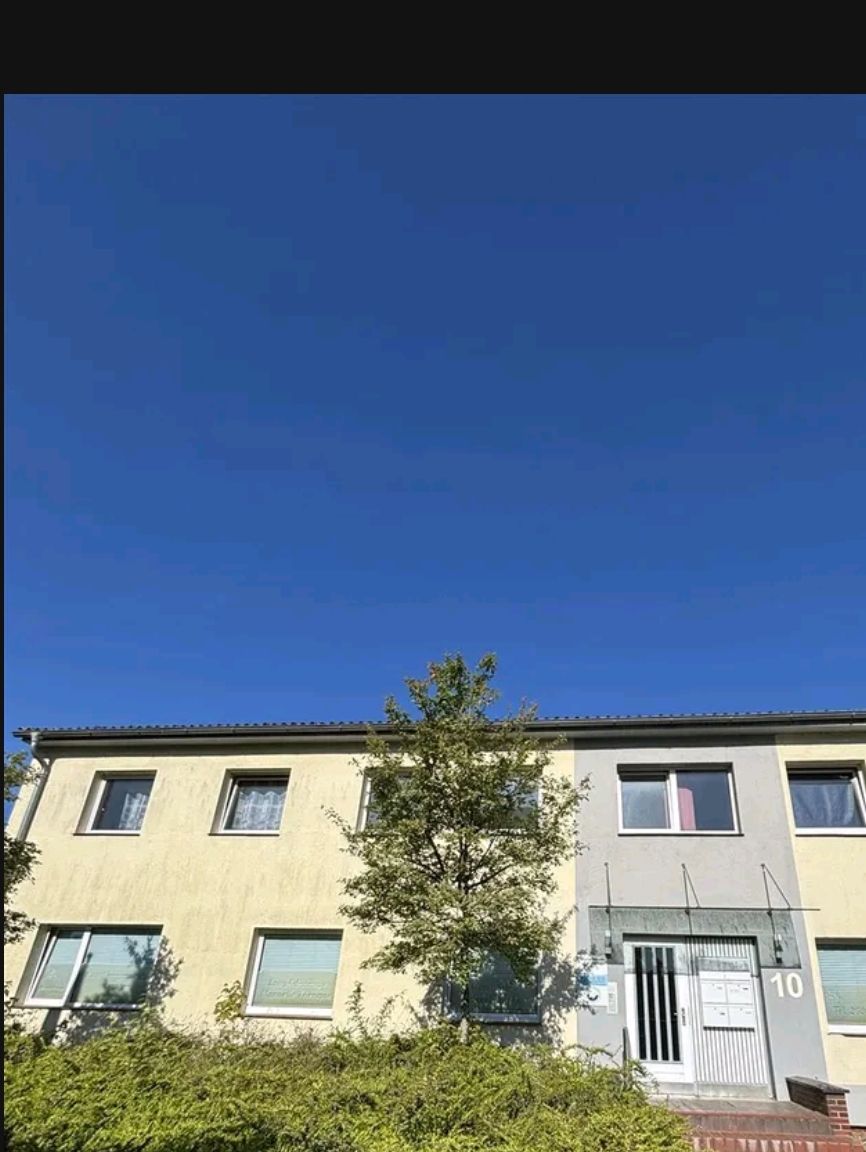 Zweist&ouml;ckiges Wohnhaus mit gelber Fassade und Vorgarten