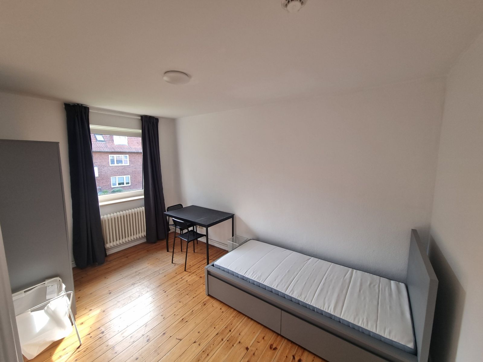 M&ouml;bliertes WG-Zimmer mit Bett, Schreibtisch, Stuhl und Holzdielenboden