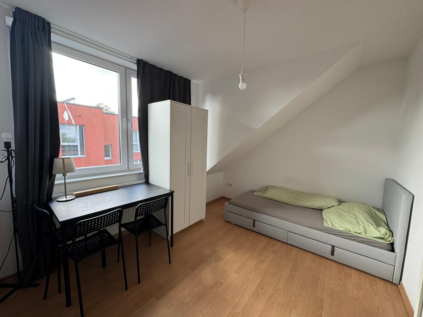 M&ouml;bliertes Zimmer unter der Dachschr&auml;ge mit Bett, Kleiderschrank, Schreibtisch und zwei St&uuml;hlen