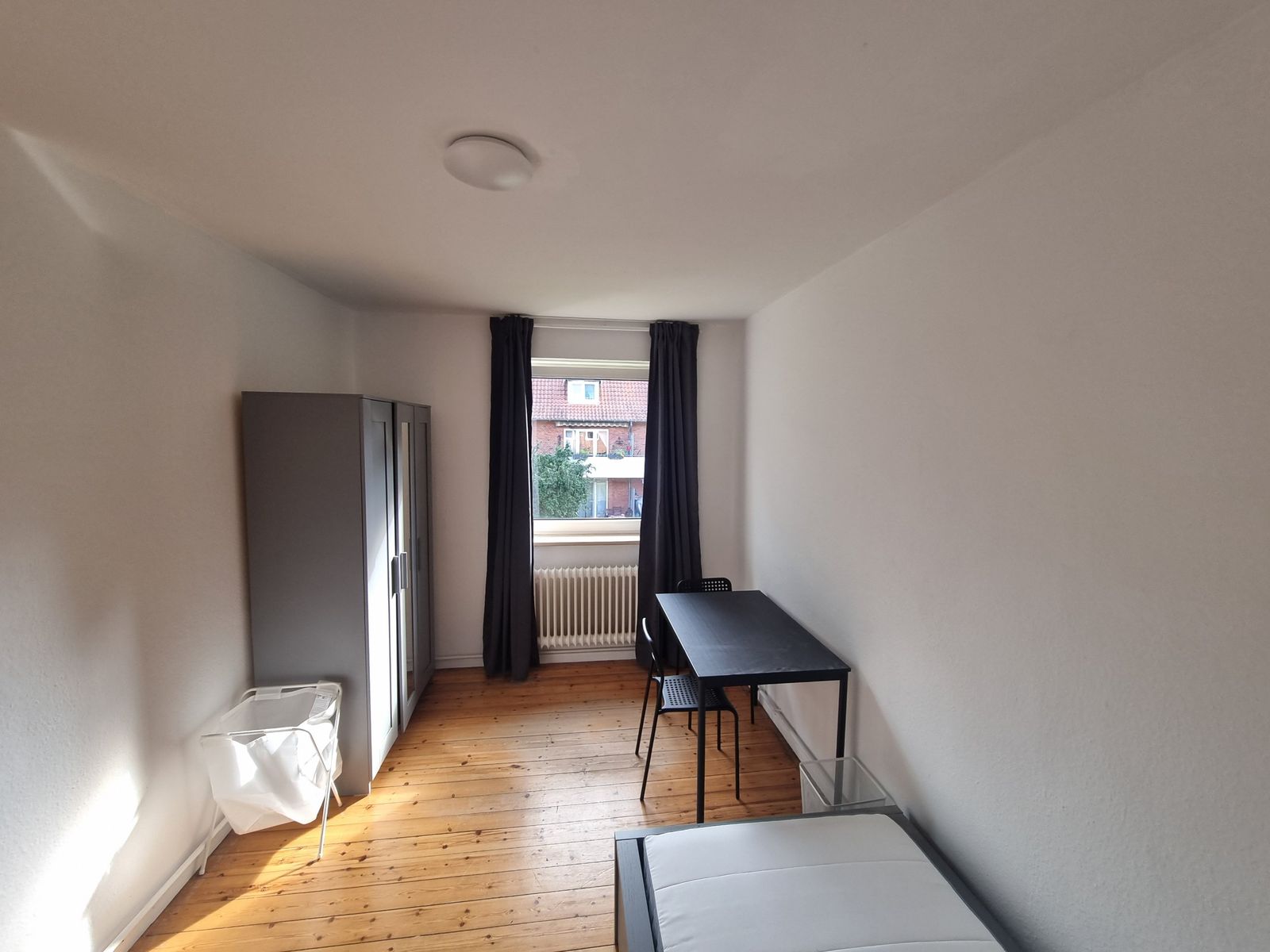 M&ouml;bliertes Zimmer mit Kleiderschrank, Schreibtisch und zwei St&uuml;hlen